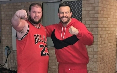Chris and Lincoln standing in a boxing position wearing red sport clothes