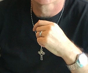 Photo of a hand holding a cross necklace