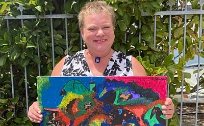 A person holding a painted artwork